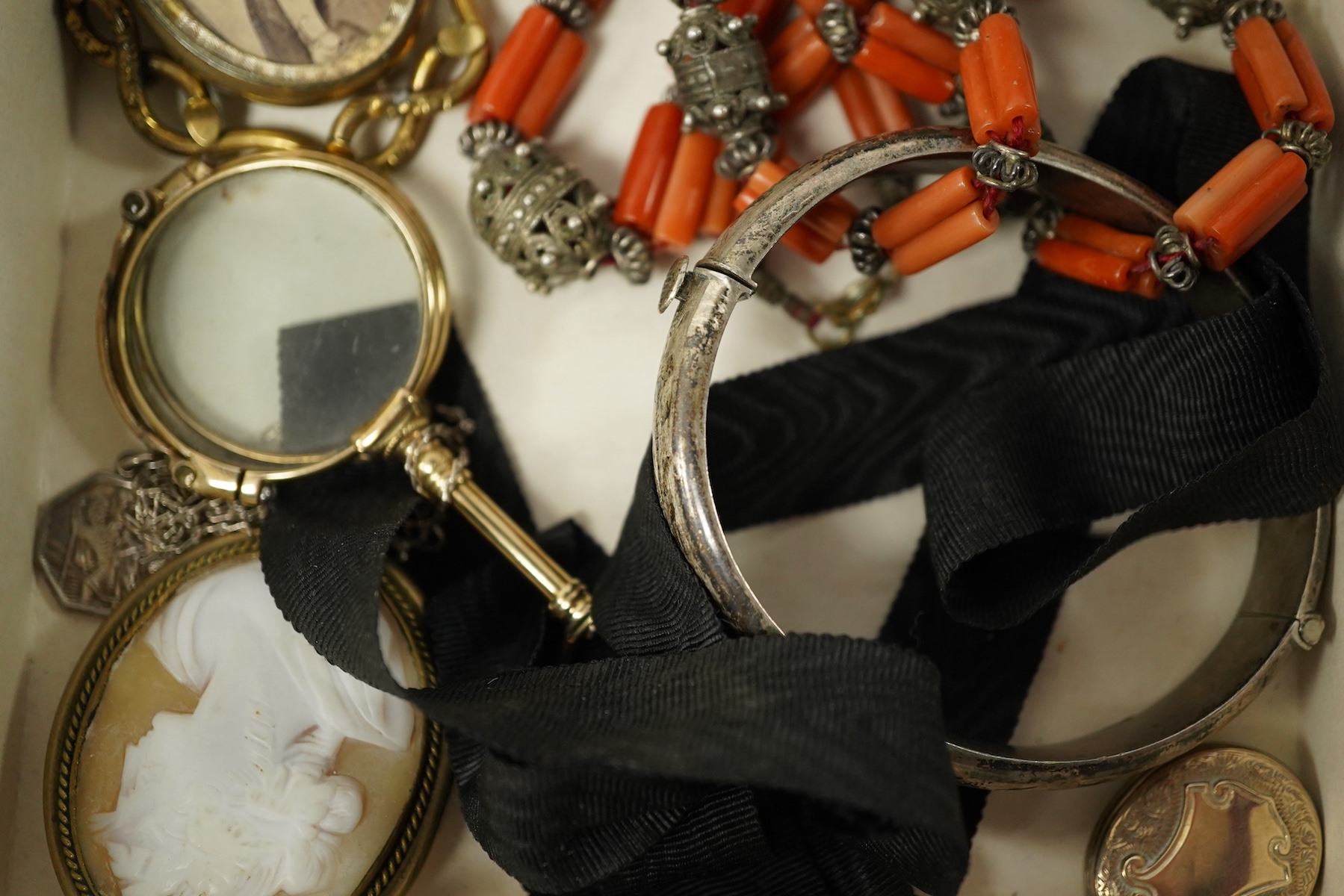 A small collection of mainly antique jewellery including coral beads, pair of lorgnettes, a gold plated oval locket etc. Condition - poor to fair